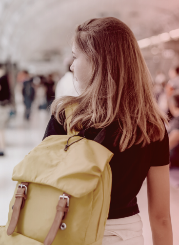 Una chica anda por la terminal del aeropuerto con su mochila